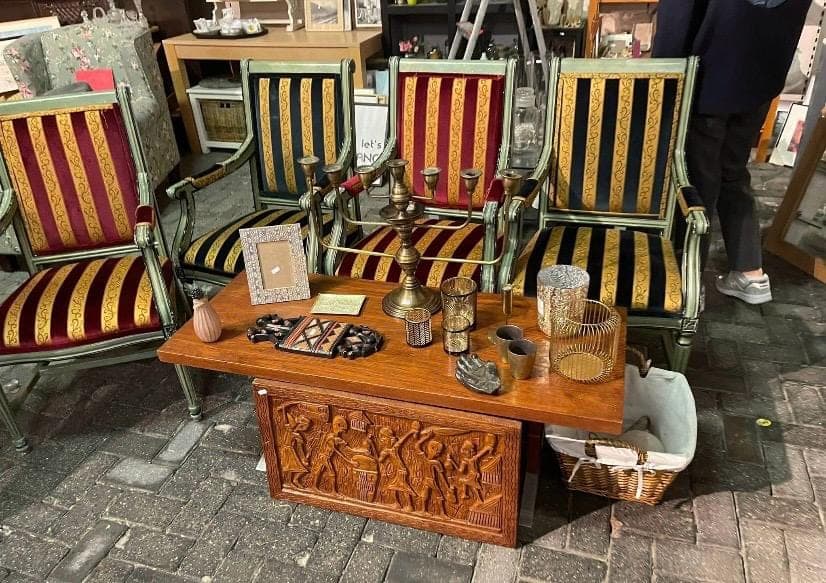 Antieke fauteuils rond een houten kist met decoratie