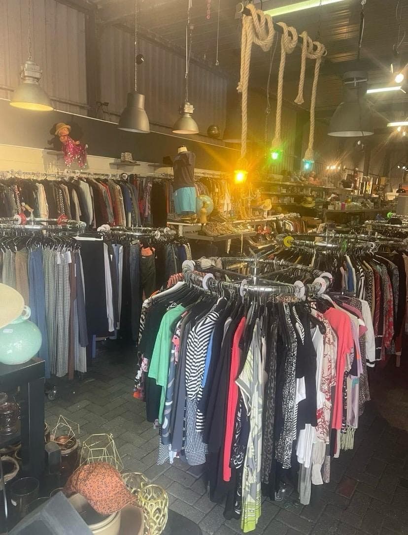 Kledingrekken vol tweedehands kleding bij kringloopwinkel Eem Struunn